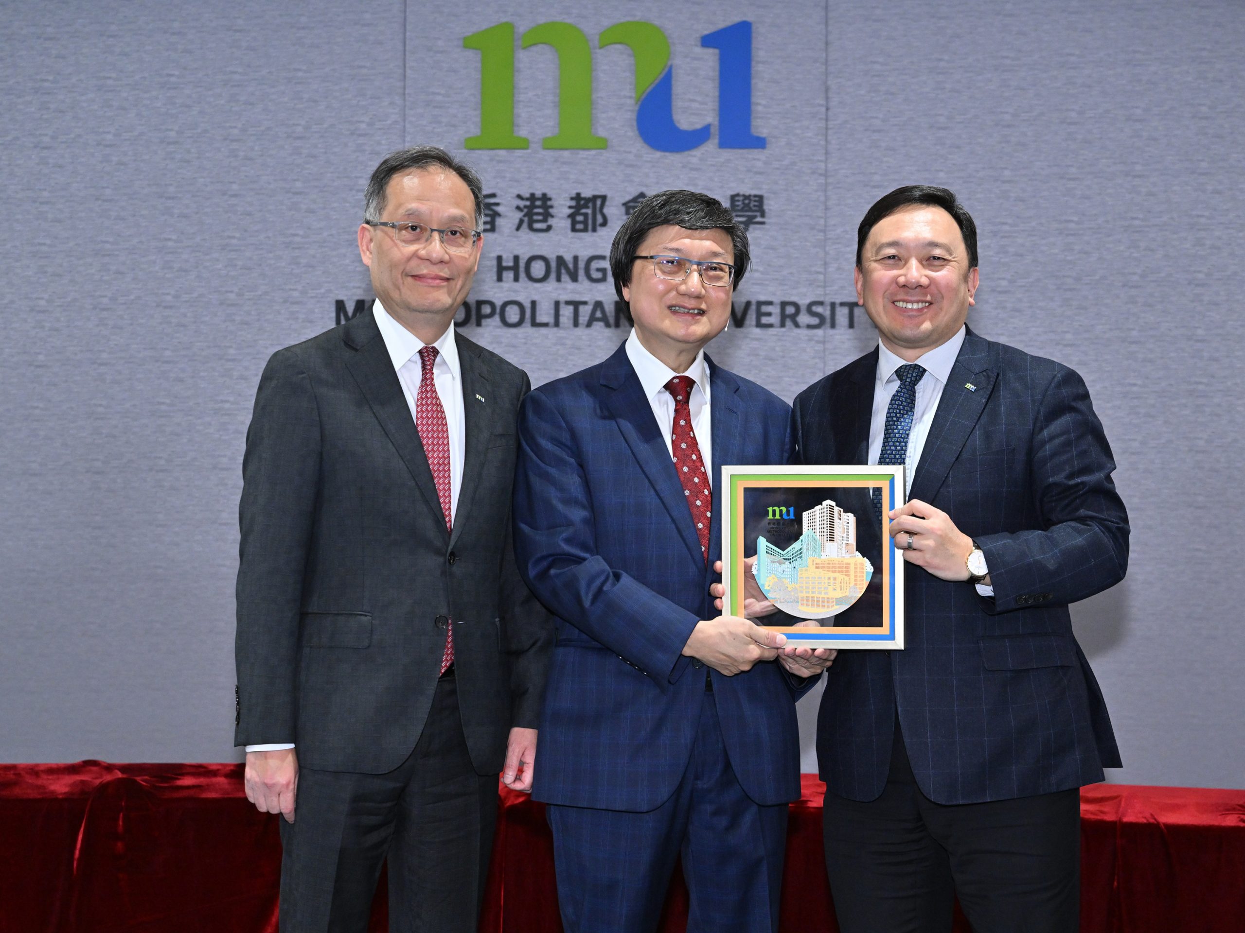 HKMU Council Chairman Ir Dr Conrad Wong Tin-cheung (right) and President Prof. Paul Lam Kwan-sing (left) present souvenirs to the speaker, Mr Franklin Lam.