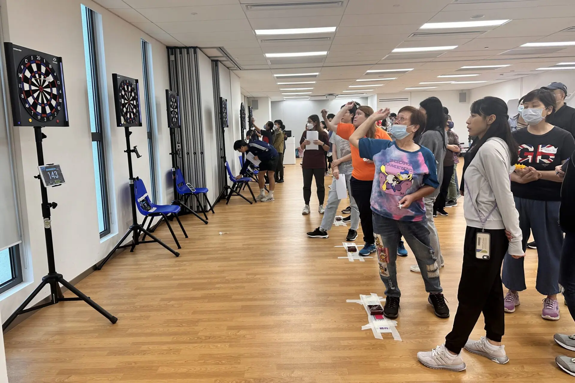 Student volunteers join hands with visually impaired athletes in a darts tournament to promote inclusion