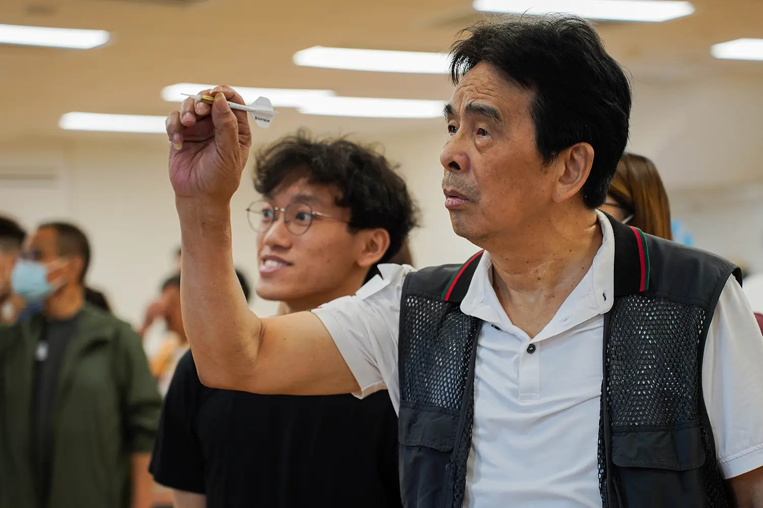 Student volunteers join hands with visually impaired athletes in a darts tournament to promote inclusion