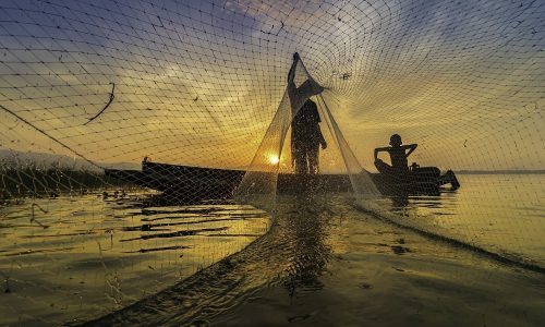 Image is silhouette. Fishermen Casting are going out to fish early in the morning with wooden boats, old lanterns and nets. Concept Fisherman's life style.