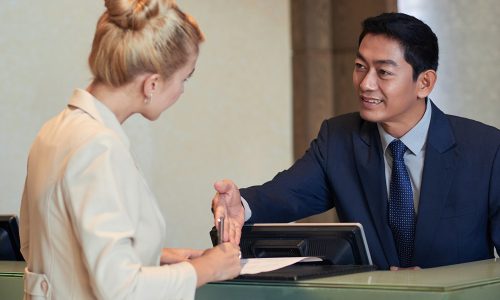Business lady filling document on reception of hotel or office building